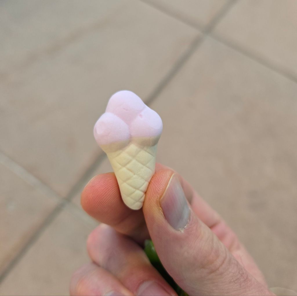 A small gummy candy in the shape of an ice cream cone with three scoops.