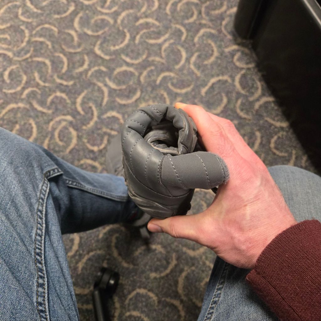 A light-duty boot rolled up tightly into a cylinder roughly the size of a soda can.